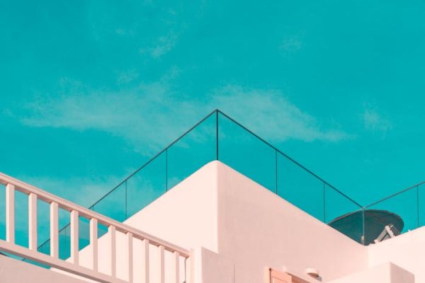 Explore the clean lines of modern Cycladic architecture under a clear blue sky in Platis Gialos, Greece.